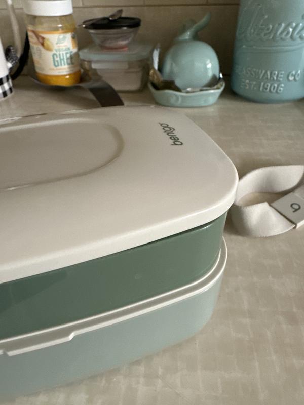 It's very hard to tell from the photo, but the lid just rests on top. It does NOT stay closed