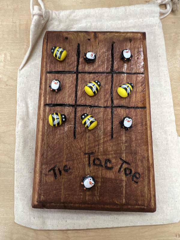 Game board with magnetic tic tac toe characters